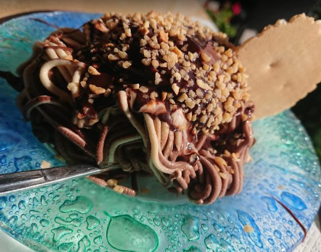 Spaghetti-Eis mit Schokosoße und gehackten Nüssen